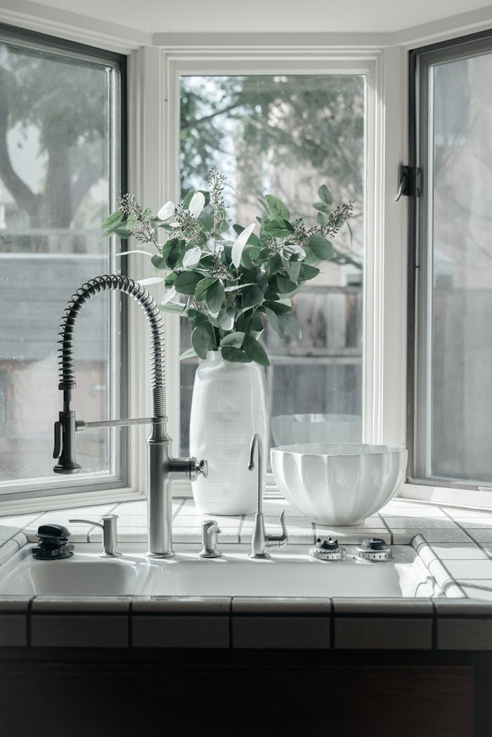 Services-02 Bright kitchen with modern faucet and eucalyptus in a vase, creating a serene ambiance.